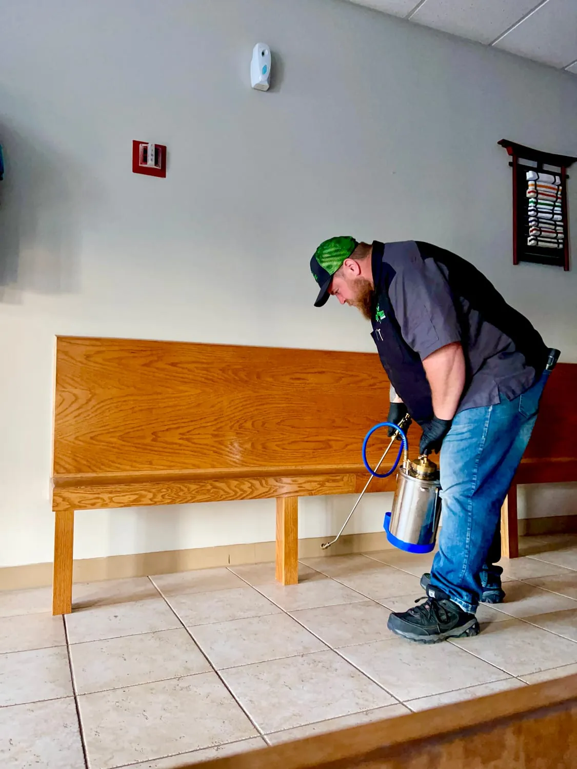 BugBoss treating along an interior wall for ants during a home service call